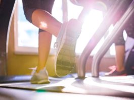 Close up of legs of two women running on treadmills in a gym, sunny day with top rated shoes