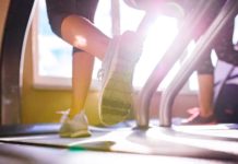 Best Running Shoes for Treadmill in 2020 Close up of legs of two women running on treadmills in a gym, sunny day with top rated shoes